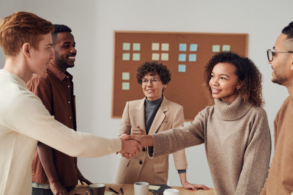 woman shaking hands with man in group of people